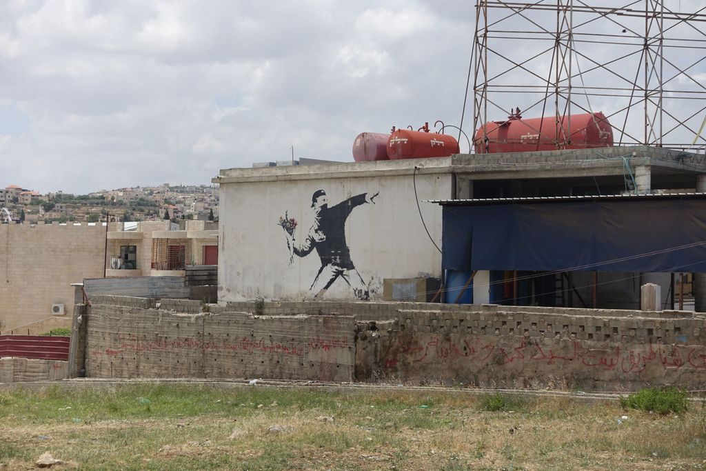 Banksy – Love Is In The Air, Flower Thrower, 2005, Ash Salon Street, Bethlehem, West Bank, photo- CC BY 2.0 by jensimon7