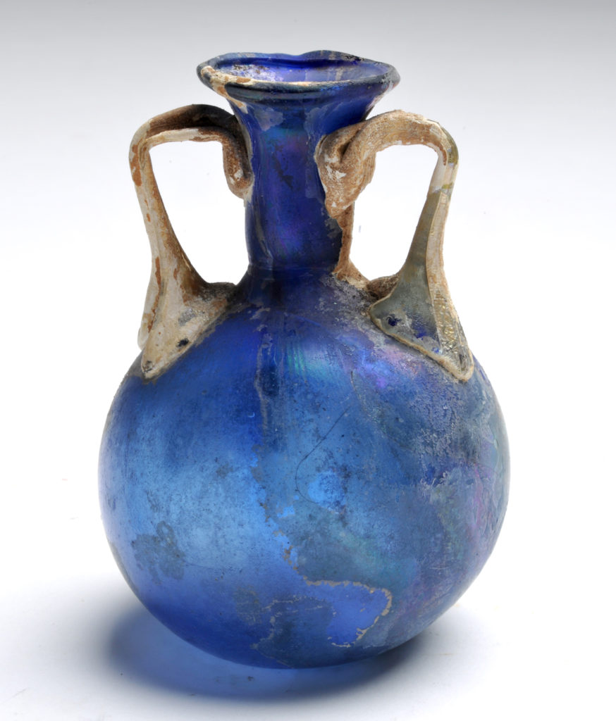Collezione strada - Balsamario biansato in vetro soffiato blu, con anse bianche applicate, da Garlasco. Prima metà I secolo d.C.